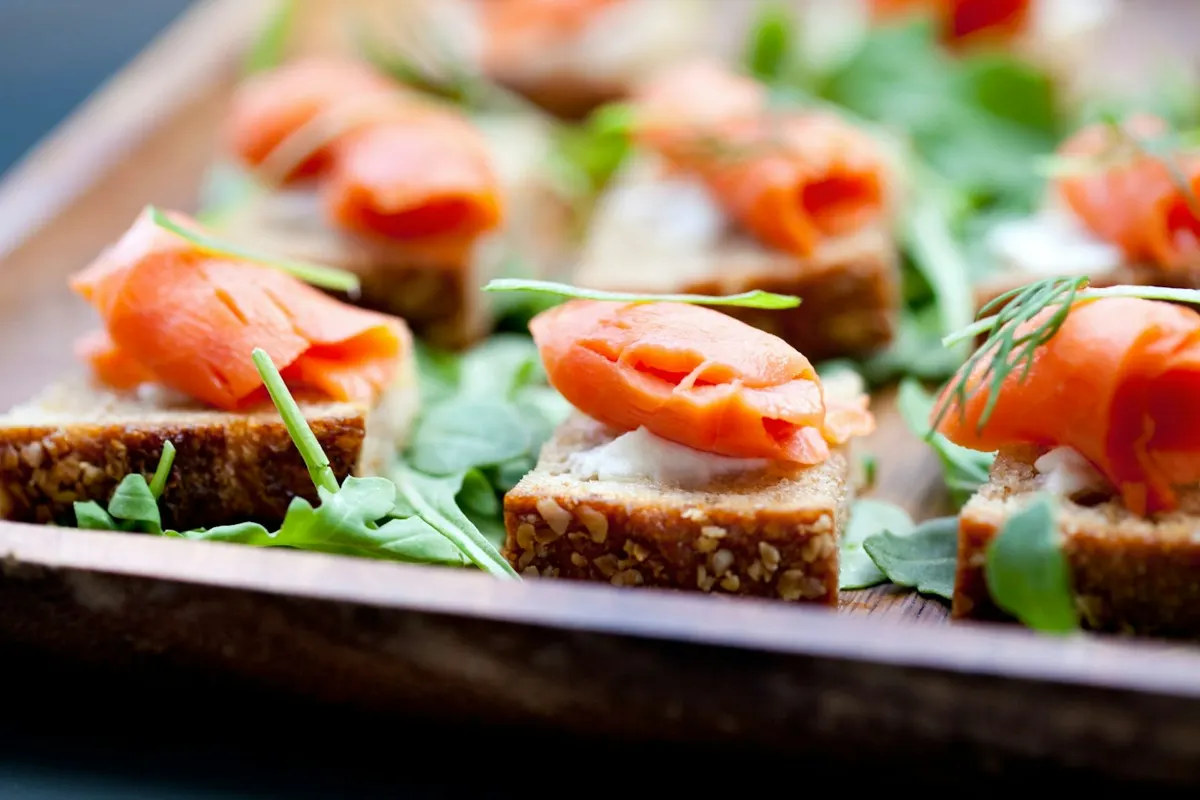Smoked salmon canapés on dark rye with arugula